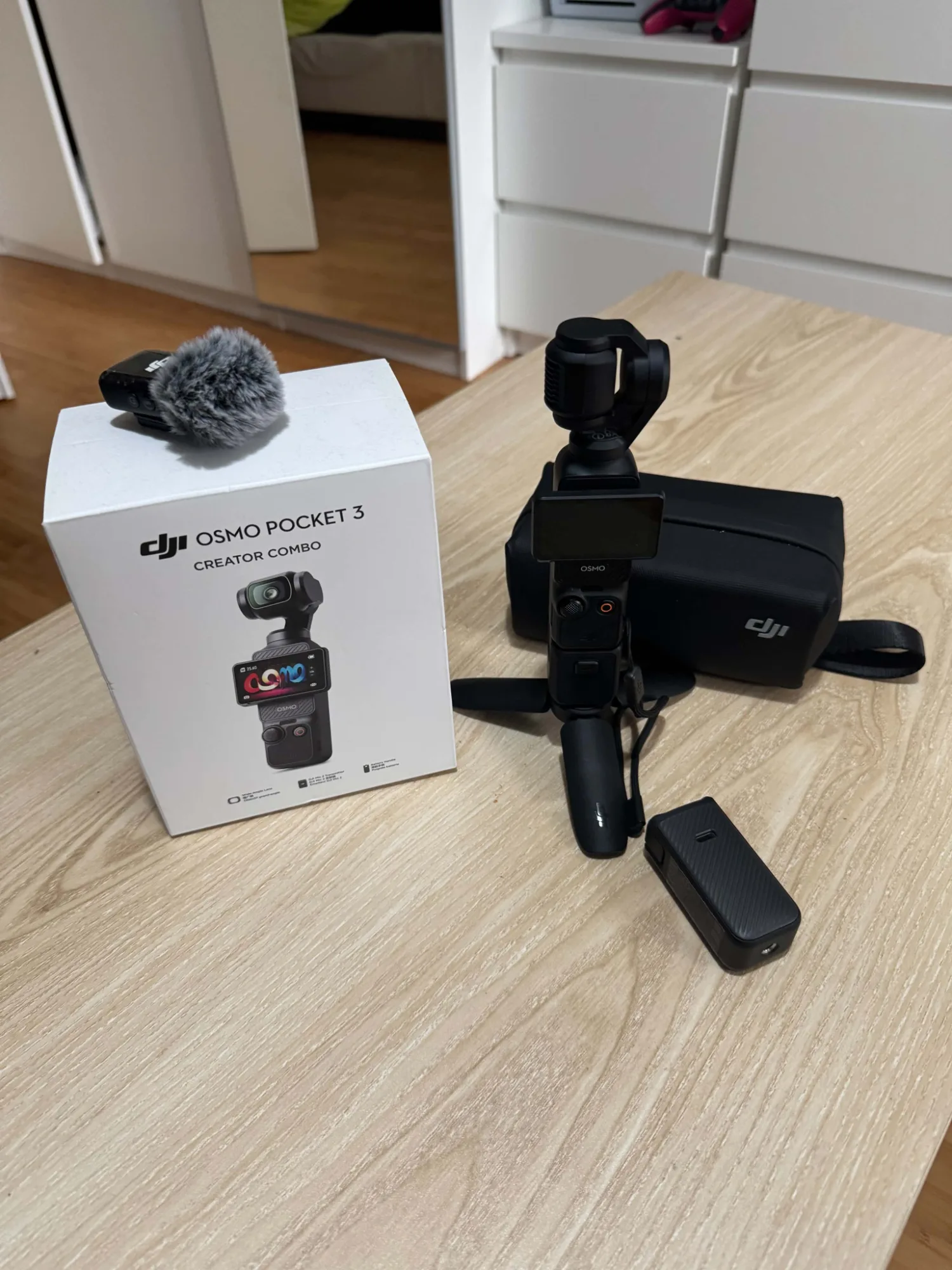 DJI Osmo Pocket 3 mit Zubehör, Tasche, Mikrofon und Originalverpackung auf Holztisch